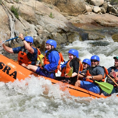 a group of people riding on a raft in the water