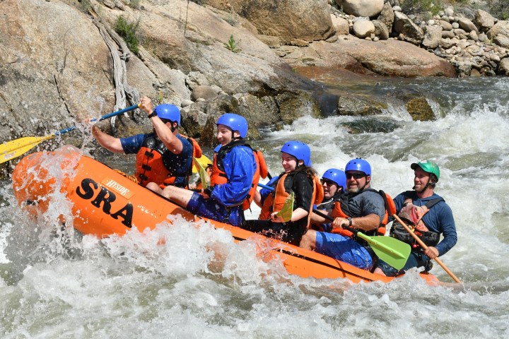 a group of people riding on a raft in the water