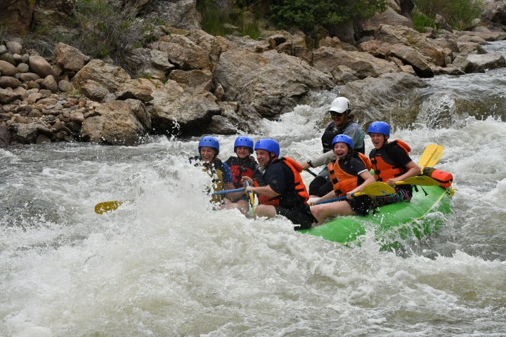 a group of people riding on a raft in the water