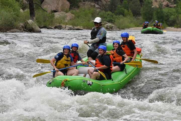 a group of people riding on a raft in the water