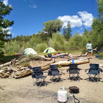 a group of people sitting at a beach umbrella in the sand