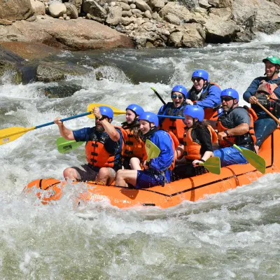 a group of people riding on a raft in the water