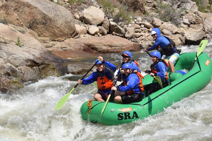 a group of people riding on a raft in the water