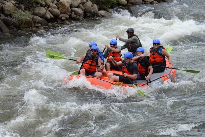 a group of people riding on a raft in a body of water