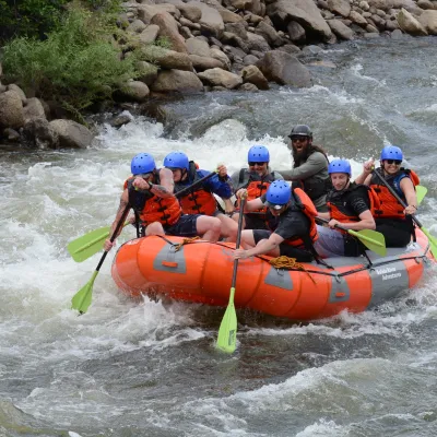 a group of people riding on a raft in the water