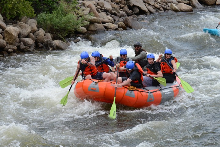 a group of people riding on a raft in the water