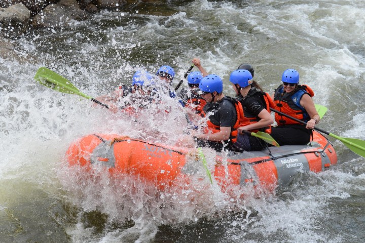 a group of people riding on a raft in the water