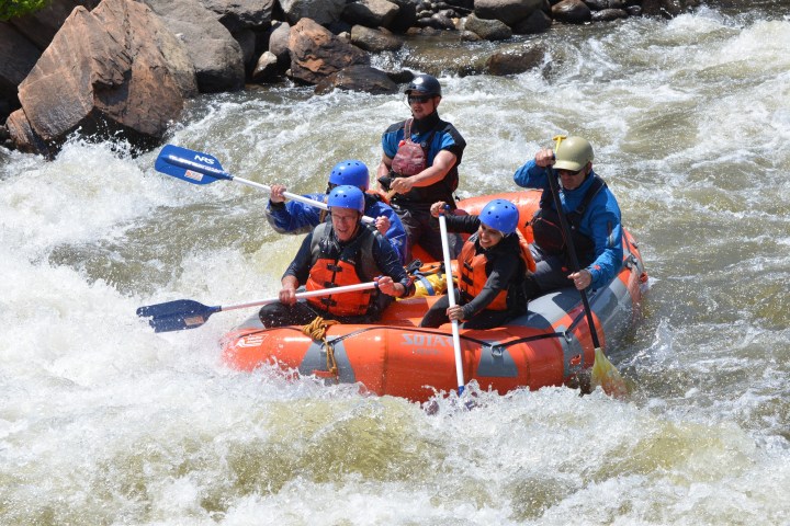a group of people riding on a raft in a body of water