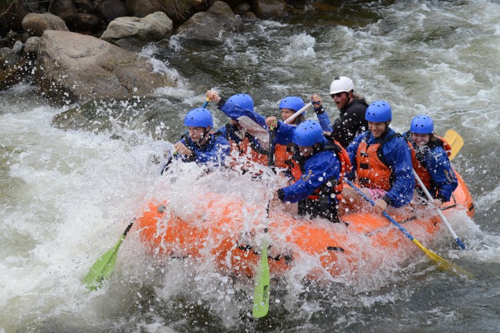a group of people riding skis on a raft in the water