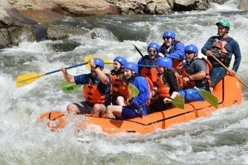 a group of people riding on a raft in a body of water
