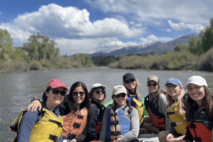 a group of people sitting next to a body of water